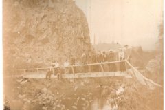 Group of people standing and sitting on a wood bridge