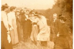 Group of men and women standing in a field.