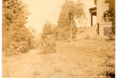 Nellie sitting with her dog on the North lawn of the Flavel House