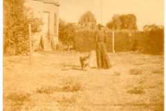 Nellie Flavel and her dog on the Flavel House lawn.