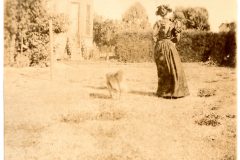 Nellie Flavel and her dog on the Flavel House lawn.