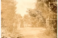 Nellie Flavel and her dog on the Flavel House lawn.