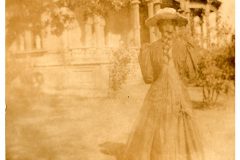 Woman with long hair half braided standing outside the Flavel House